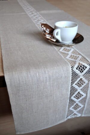 Linen table runner with lace on the middle along of the runner. And the lace is see though the table.
