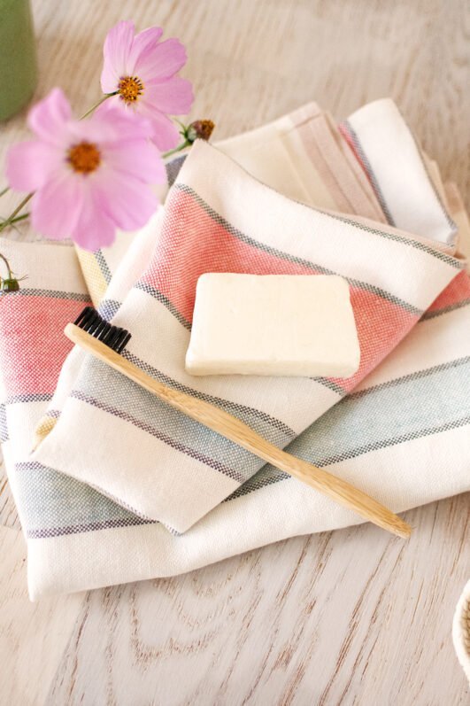 Off white heavy linen towels for hands, face or guests, to use in the bathroom. Off white towels are with pastel colors stripes.