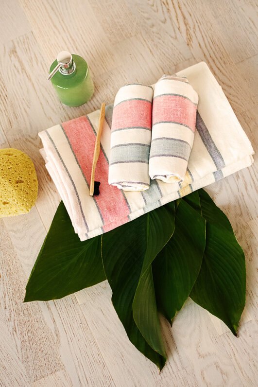 Off white heavy linen towels for hands, face or guests, to use in the bathroom. Off white towels are with pastel colors stripes.