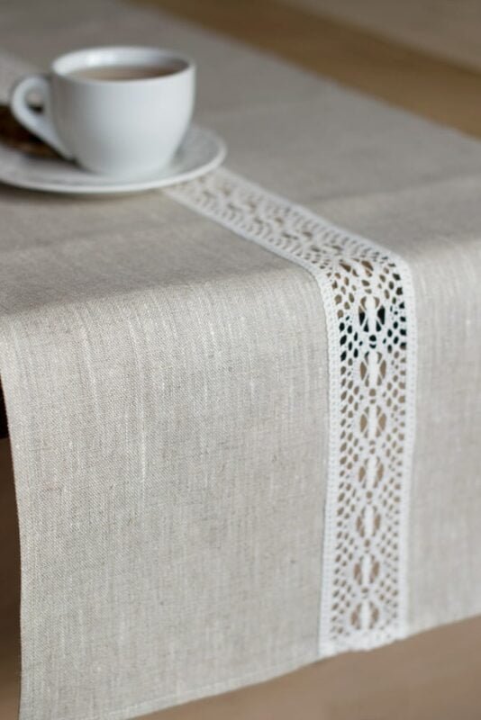 beige linen table runner with off white linen lace in the center, the table see through.