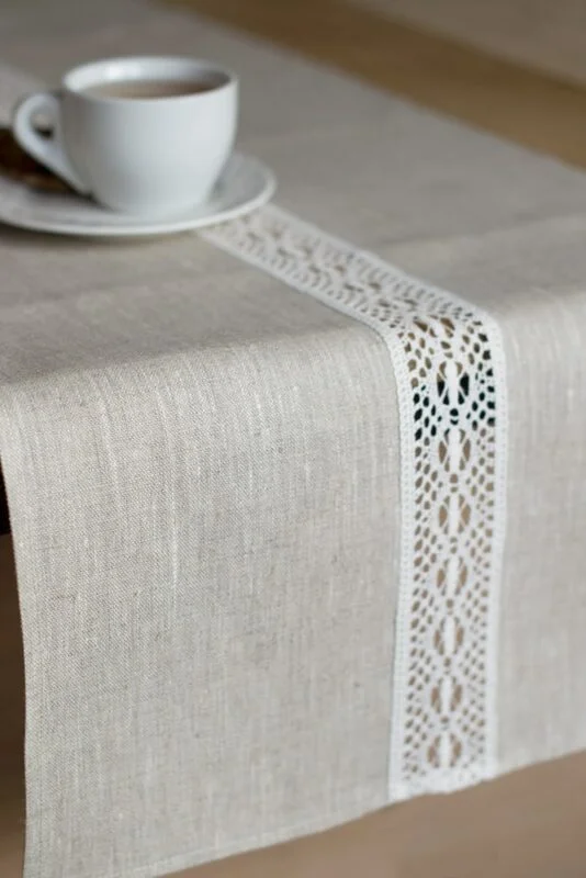 beige linen table runner with off white linen lace in the center, the table see through.