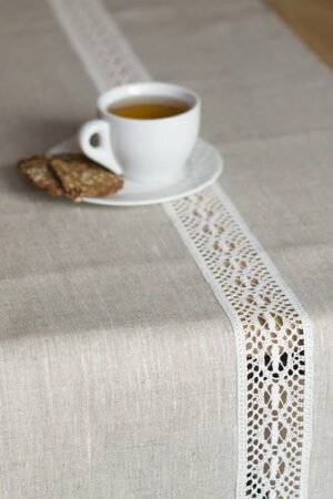 beige linen table runner with off white linen lace in the center, the table see through.