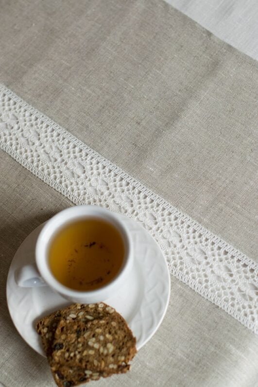 beige linen table runner with off white linen lace in the center, the table see through.