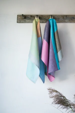 Set of 2 colorful striped linen towels. One with pastel colors wide stripes, the other with bright hues.