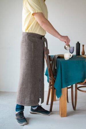 Brown linen long half apron is made with a slit on front and it helps to keep moving comfortable and the apron has the pockets on the sides. The belt is made long enough. Look great as cafe or restaurant apron.