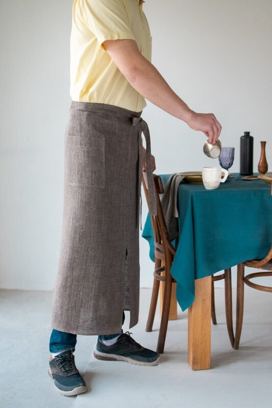 Brown linen long half apron is made with a slit on front and it helps to keep moving comfortable and the apron has the pockets on the sides. The belt is made long enough. Look great as cafe or restaurant apron.
