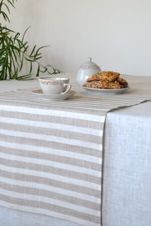 Short natural striped linen table runner with stripes goes across the runner.