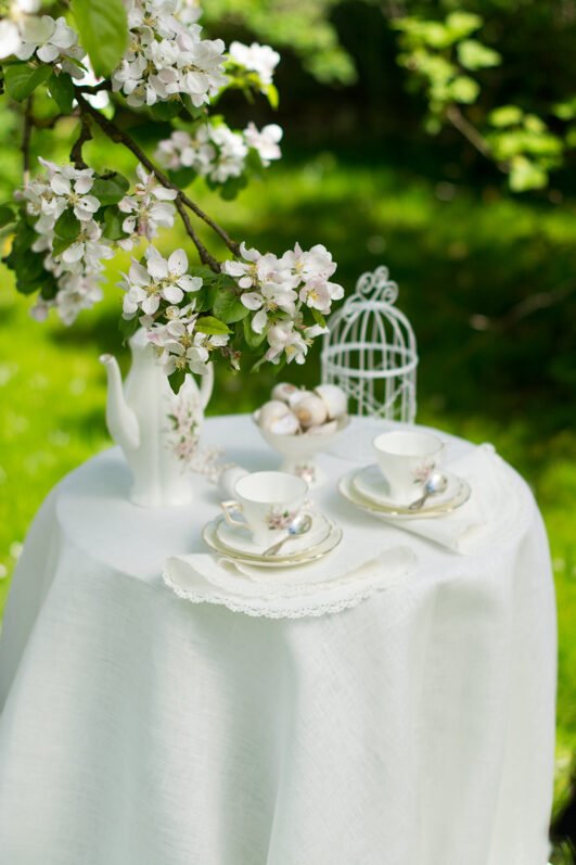 Off white round linen tablecloth on small table goes to the ground in so wonderful deep folds. This linen tablecloth layers on the ground looks so luxury. It is so elegant for Your party in the garden or at home.