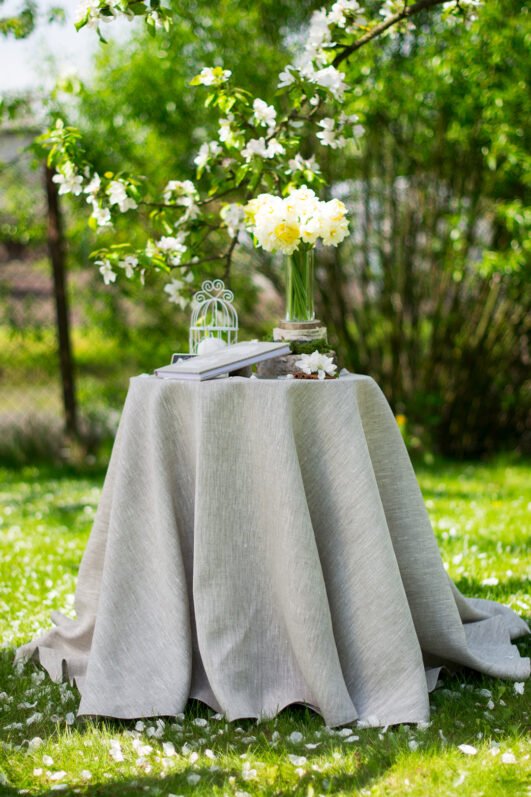 Light natural round linen tablecloth on small table goes to the ground in so wonderful deep folds. This linen tablecloth layers on the ground looks so luxury. It is so elegant for Your party in the garden or at home.