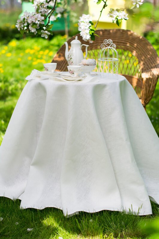 Off white round linen tablecloth on small table goes to the ground in so wonderful deep folds. This linen tablecloth layers on the ground looks so luxury. It is so elegant for Your party in the garden or at home.
