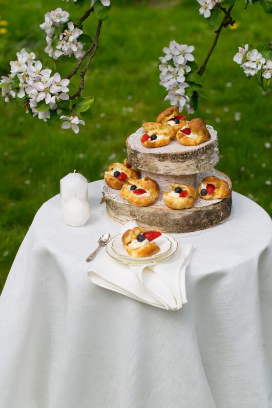 Off white round linen tablecloth on small table goes to the ground in so wonderful deep folds. This linen tablecloth layers on the ground looks so luxury. It is so elegant for Your party in the garden or at home.