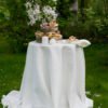 Off white round linen tablecloth on small table goes to the ground in so wonderful deep folds. This linen tablecloth layers on the ground looks so luxury. It is so elegant for Your party in the garden or at home.