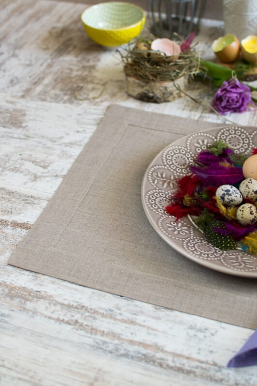 Elegant linen placemats in neutral tones (natural, light natural, off-white) with wide mitered corners. Perfect for casual or formal dining. Shop now for simple, natural table decor.