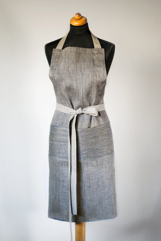 Grey linen apron made from melange linen - black with natural linen yarns. The belt is adjustable and made from natural linen. One big pocket on front.