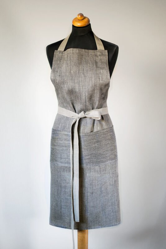 Grey linen apron made from melange linen - black with natural linen yarns. The belt is adjustable and made from natural linen. One big pocket on front.