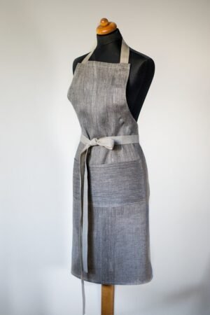 Grey linen apron made from melange linen - black with natural linen yarns. The belt is adjustable and made from natural linen. One big pocket on front.
