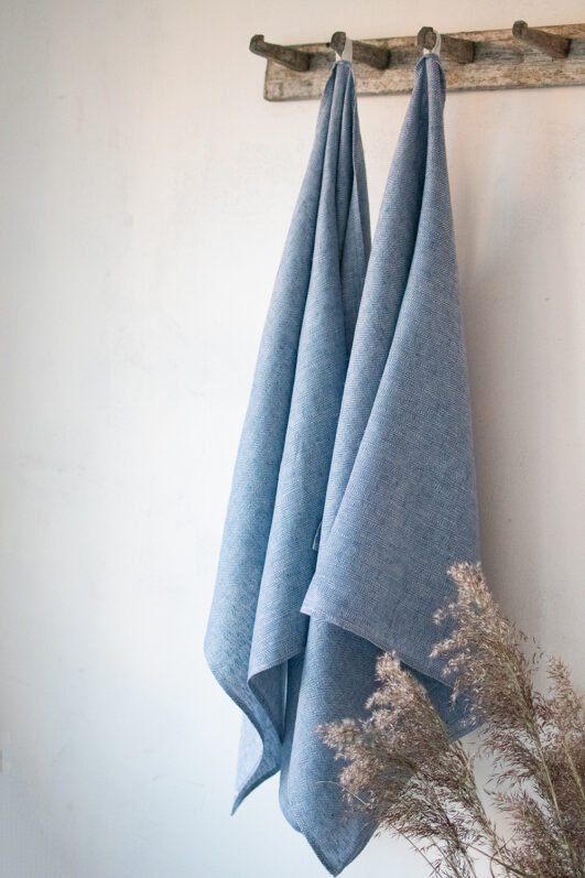 Blue linen herringbone bath towel, with a hanging loops. Blue color is lighter blue.