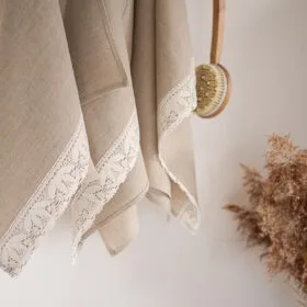Shabby chic natural linen towels decorated with white luxury wide linen lace with lotus flowers.