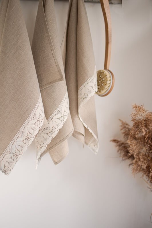 Shabby chic natural linen towels decorated with white luxury wide linen lace with lotus flowers.