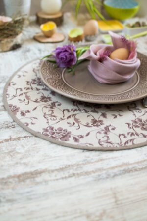 Reversible round linen cotton placemat showing both the Marsala floral side and the natural linen side with finished binding.